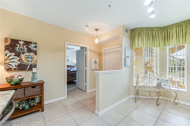 corridor with light tile patterned floors, baseboards, and visible vents