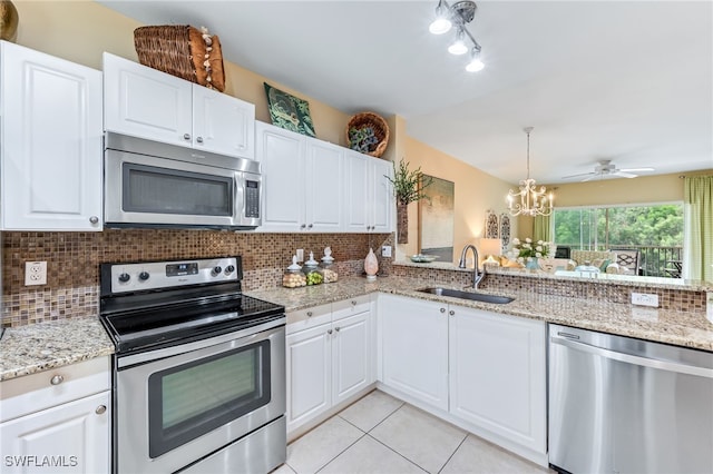 kitchen featuring white cabinets, backsplash, appliances with stainless steel finishes, and a sink