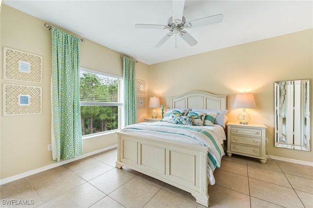 bedroom with light tile patterned floors, a ceiling fan, and baseboards