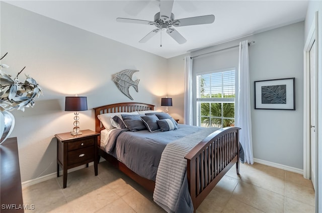 bedroom featuring light tile patterned floors, a ceiling fan, and baseboards