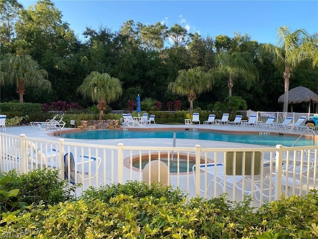 pool with a patio and fence