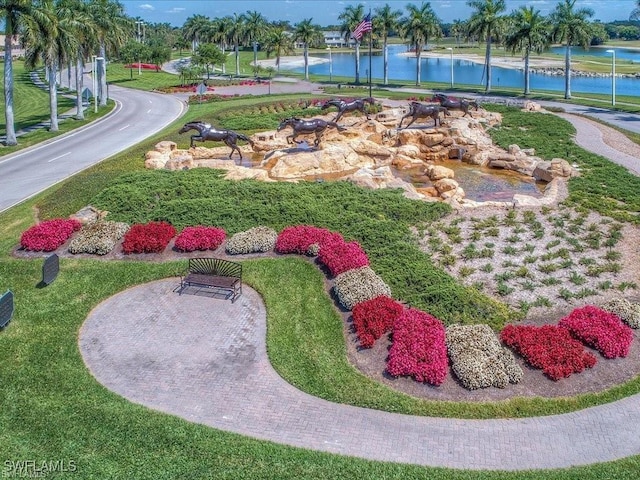 view of property's community with a lawn and a water view