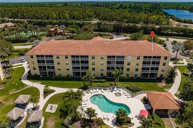 birds eye view of property with a wooded view and a water view