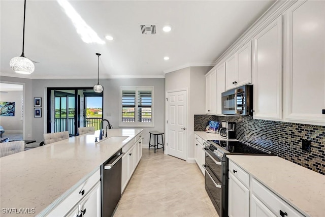 kitchen featuring light stone countertops, visible vents, a sink, decorative backsplash, and appliances with stainless steel finishes