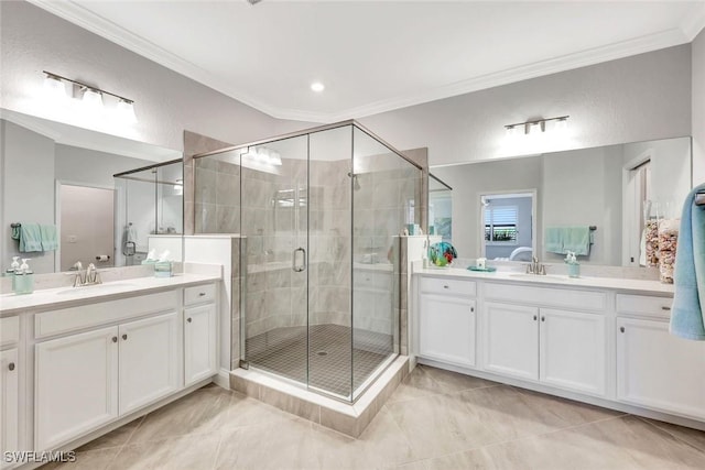 full bath featuring a sink, two vanities, ornamental molding, and a shower stall