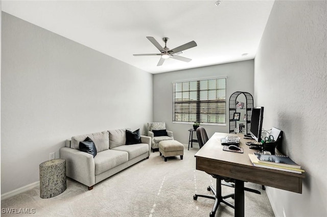 carpeted office space with baseboards and ceiling fan