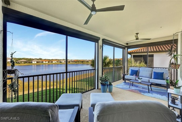 sunroom / solarium featuring ceiling fan and a water view