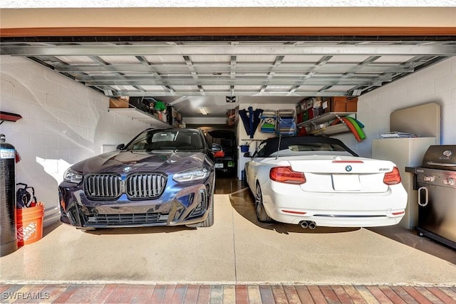 garage with concrete block wall and a garage door opener