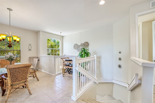 interior space featuring light tile patterned floors, a notable chandelier, baseboards, and visible vents