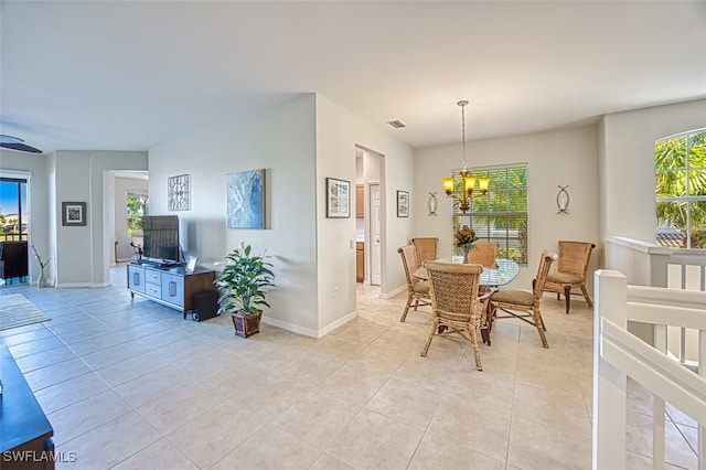 dining area featuring light tile patterned flooring, a notable chandelier, and plenty of natural light