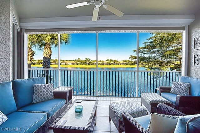 sunroom / solarium with a ceiling fan and a water view