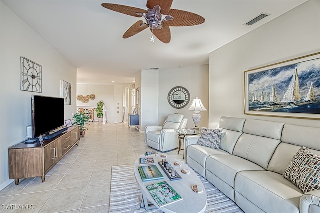 living area featuring light tile patterned floors, visible vents, baseboards, and a ceiling fan