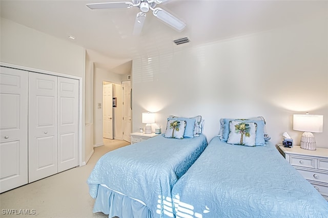 bedroom featuring light colored carpet, visible vents, a closet, and ceiling fan