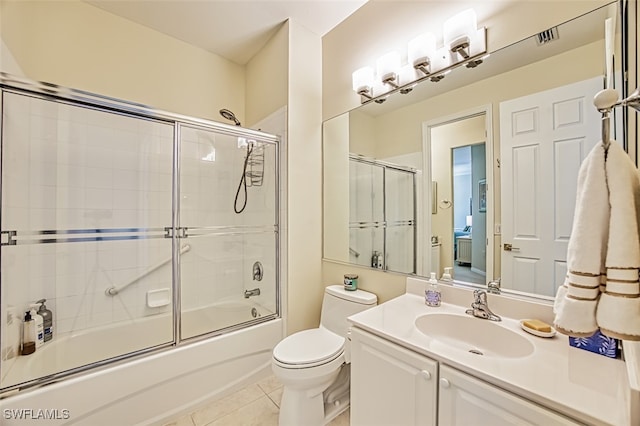 bathroom with visible vents, toilet, tile patterned flooring, enclosed tub / shower combo, and vanity