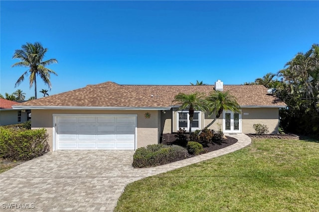 single story home with decorative driveway, french doors, a garage, and stucco siding