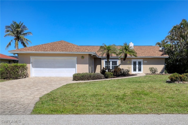 ranch-style house featuring stucco siding, decorative driveway, french doors, a front yard, and a garage