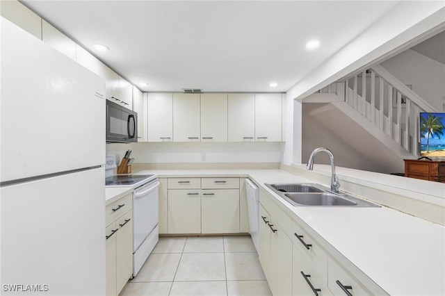 kitchen featuring white appliances, visible vents, light tile patterned flooring, a sink, and light countertops