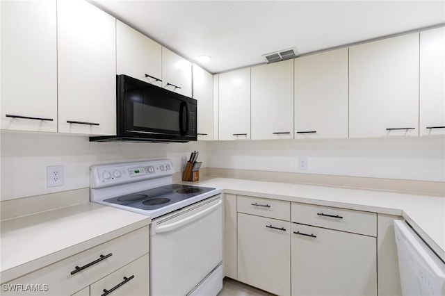 kitchen with visible vents, white appliances, white cabinetry, and light countertops