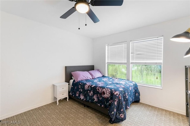 bedroom with ceiling fan and baseboards