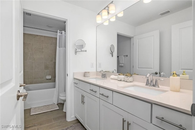 full bathroom with a sink, visible vents, toilet, and wood tiled floor