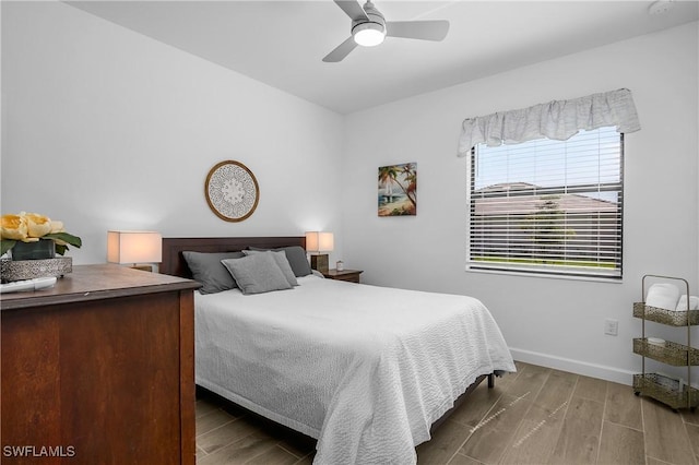 bedroom with wood finished floors, baseboards, and ceiling fan