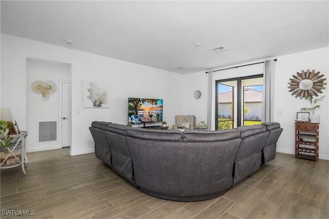 living room featuring visible vents, baseboards, and wood finished floors