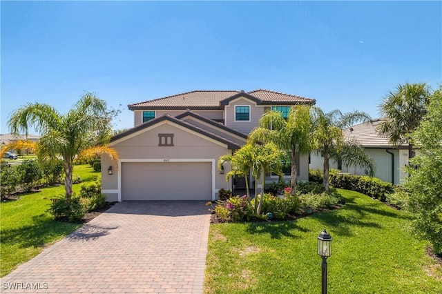 view of front facade with a tile roof, a front lawn, decorative driveway, and a garage