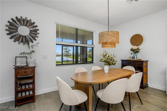 dining room with visible vents, light wood-style floors, and baseboards