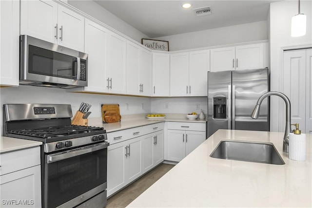 kitchen with visible vents, stainless steel appliances, light countertops, and a sink