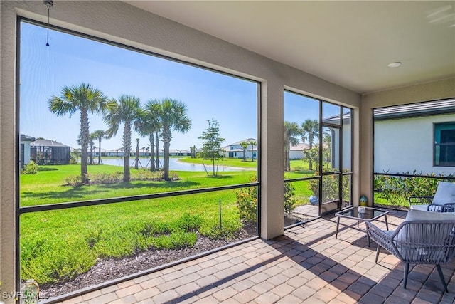 unfurnished sunroom featuring a water view