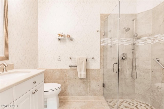 bathroom featuring wallpapered walls, toilet, vanity, and a stall shower