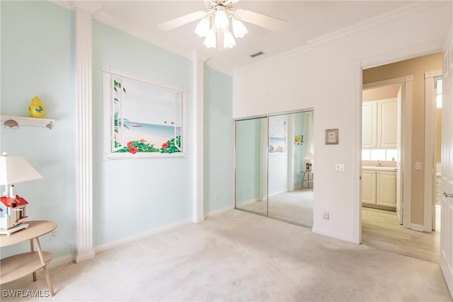 unfurnished bedroom featuring visible vents, crown molding, baseboards, light carpet, and a closet