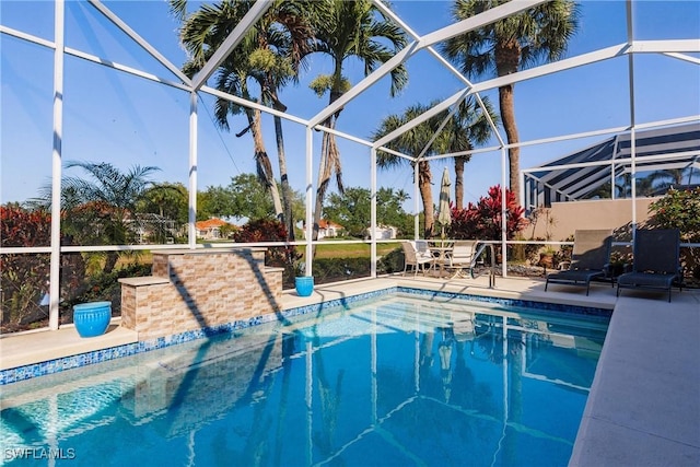 outdoor pool with glass enclosure and a patio area