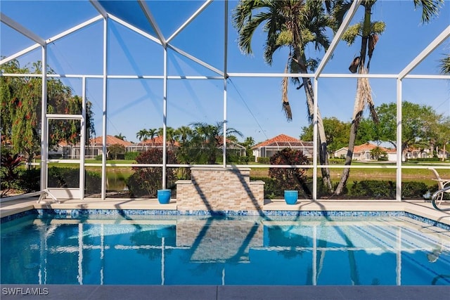 outdoor pool featuring glass enclosure and a patio