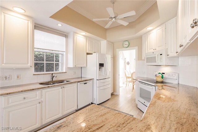 kitchen with white cabinetry, white appliances, decorative backsplash, and a sink