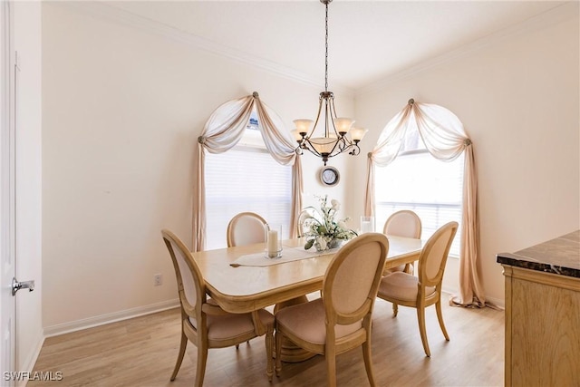 dining space featuring light wood finished floors, baseboards, an inviting chandelier, and ornamental molding