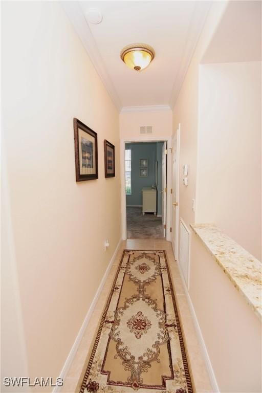 hall with visible vents, baseboards, and crown molding