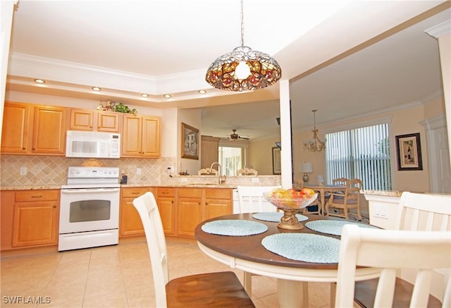 kitchen with white appliances, ornamental molding, light countertops, tasteful backsplash, and a chandelier