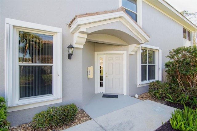 view of exterior entry featuring stucco siding