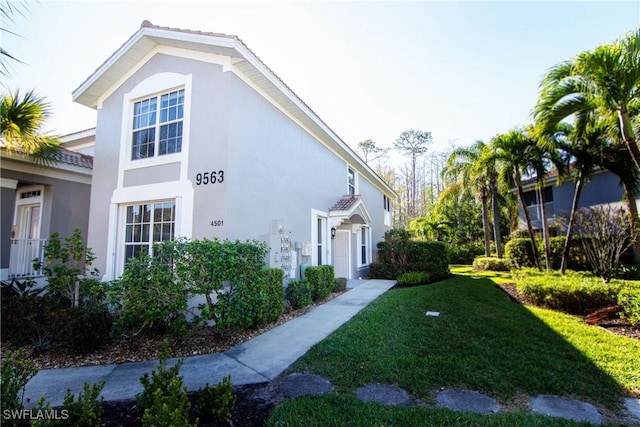 view of front of house with a front yard and stucco siding