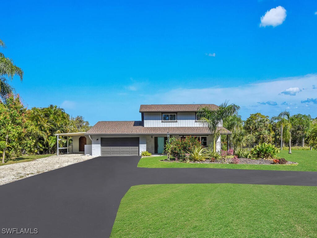 1831 Seminole Harbor Dr, Alva, FL 33920 - view of front of home featuring aphalt driveway, an attached garage, and a front yard