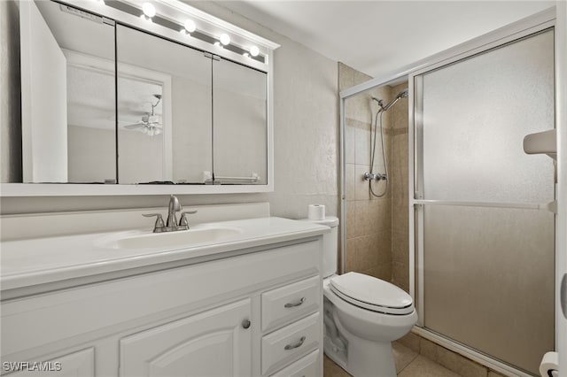 bathroom featuring vanity, toilet, a stall shower, and tile patterned flooring