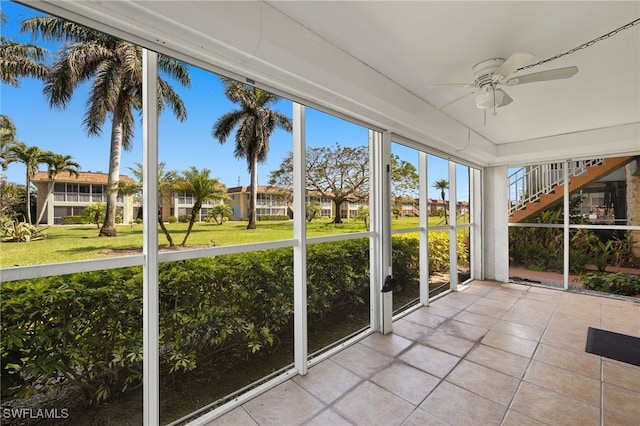 unfurnished sunroom featuring ceiling fan