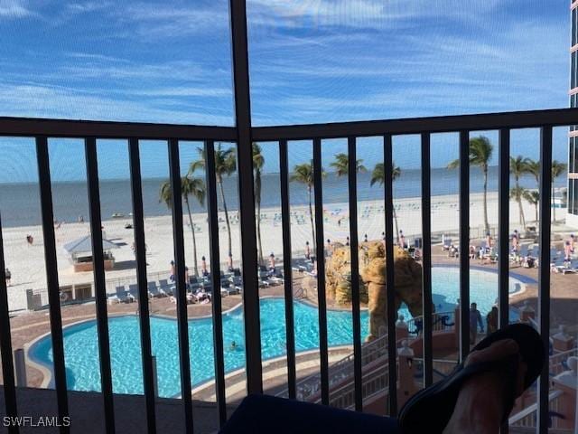 balcony featuring a beach view and a water view