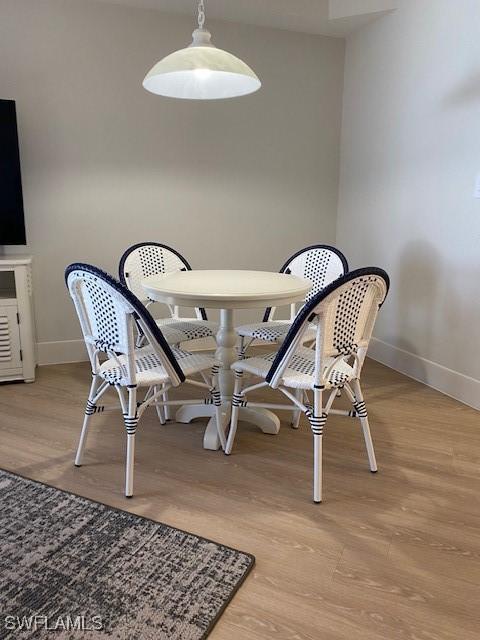 dining area with baseboards and wood finished floors