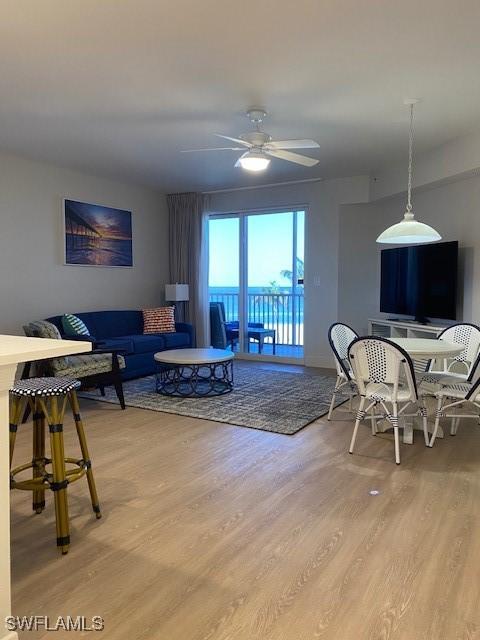 living area featuring light wood-type flooring and ceiling fan