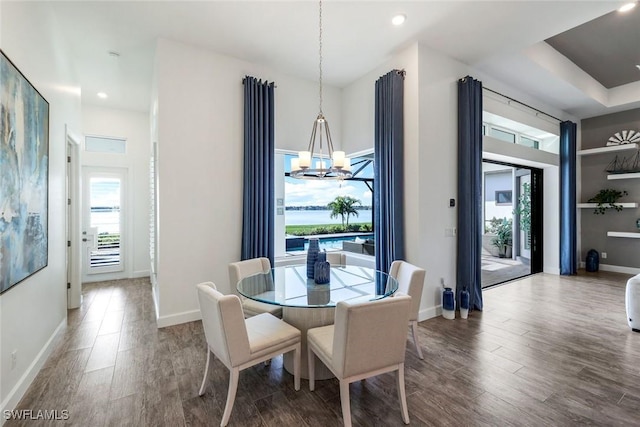 dining space featuring an inviting chandelier, recessed lighting, wood finished floors, and baseboards