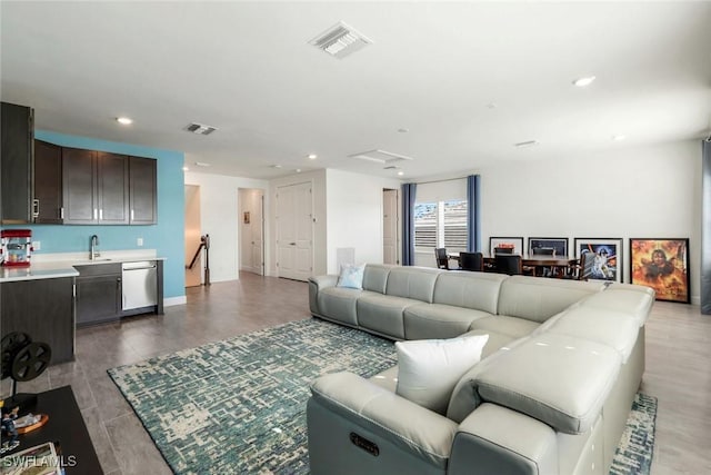 living room with light wood-style floors, recessed lighting, visible vents, and baseboards