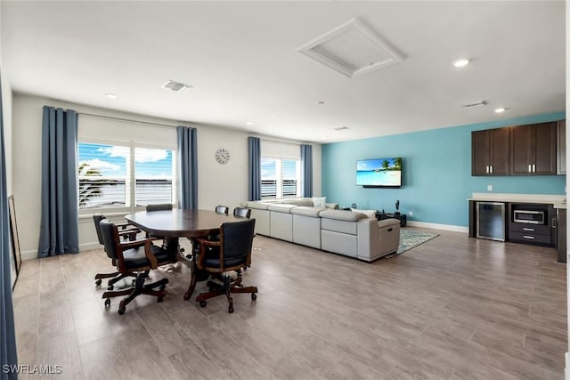 dining room featuring beverage cooler, visible vents, a healthy amount of sunlight, and attic access