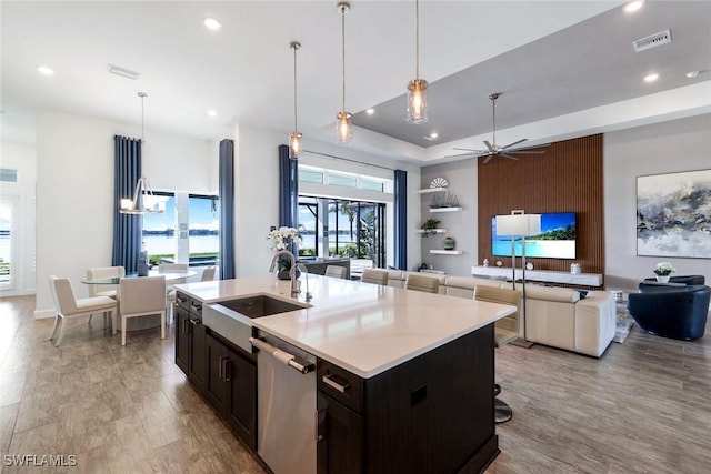 kitchen with visible vents, a sink, light countertops, dishwasher, and open floor plan